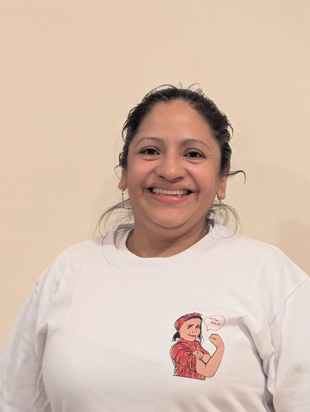 Smiling DA Maids crew member in a white crew tee with the mascot crest