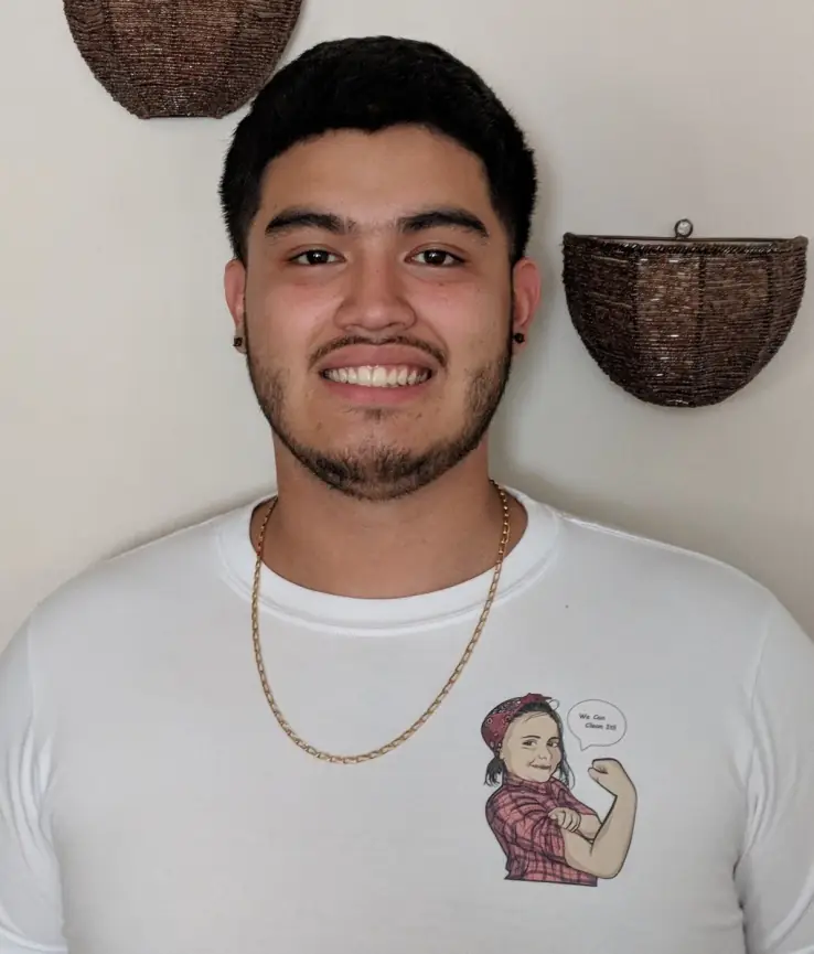 Young DA Maids crew member in a white crew tee with the mascot crest